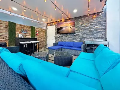 a living room with blue couches and a bar at Vacay Spot experience Luna Sky! 65