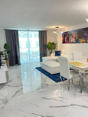 a living room with white furniture and a marble floor at Lujoso apartamento en Brickell in Miami