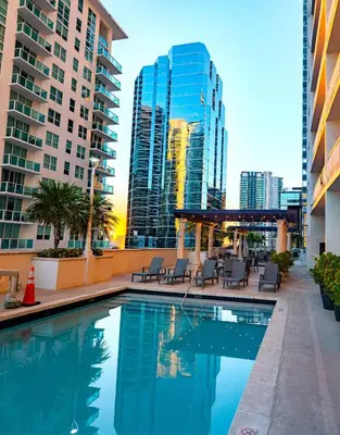 a swimming pool with chairs and buildings in the background at Lujoso apartamento en Brickell in Miami
