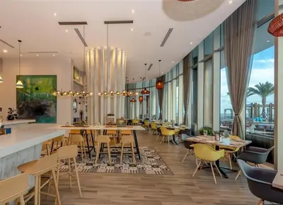 a restaurant with tables and chairs and windows at Ocean Front State Of The Art in Hollywood