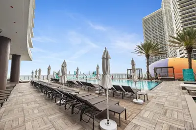 a pool with chaise lounge chairs and umbrellas at Zen Vacation Rentals Ocean front 3 3 MAZAL in Hollywood