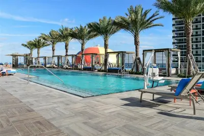 a pool on the roof of a building with palm trees at Zen Vacation Rentals Direct Ocean Front Low Floor in Hollywood