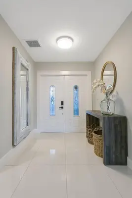 a large white room with a hallway with a door at Citrus+Sunshine/Heated Pool/6 min to Beach/Casino in Dania Beach