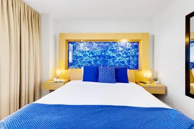 a bedroom with a large bed with blue pillows at Beachfront Resort - Pool - Ocean View Balcony- Gym in Miami Beach