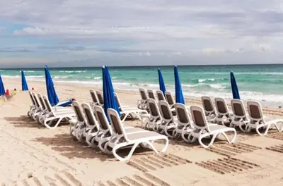 a row of chairs and umbrellas on a beach at Beachfront Resort POOL OCEAN VIEW BALCONY in Miami Beach