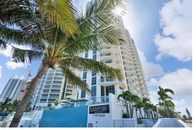 a tall building with a palm tree in front of it at Beachfront Resort POOL OCEAN VIEW BALCONY in Miami Beach