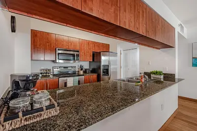 a kitchen with granite counter tops and wooden cabinets at Miami condo with city & ocean views! Sleep up to 6! in Miami