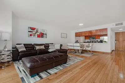 a living room with a brown couch and a kitchen at Miami condo with city & ocean views! Sleep up to 6! in Miami