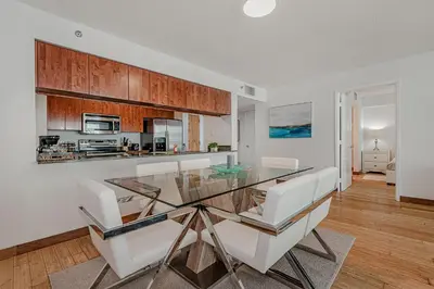 a dining room with a glass table and white chairs at Miami condo with city & ocean views! Sleep up to 6! in Miami