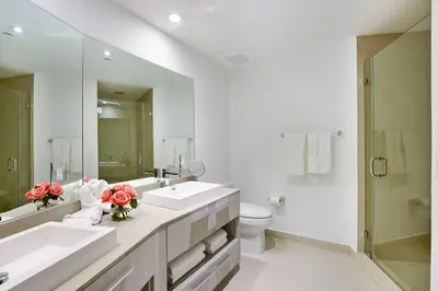 a bathroom with two sinks and a toilet and a mirror at Million Dollar Ocean Front Penthouse by Zen Vacation Rentals in Hollywood