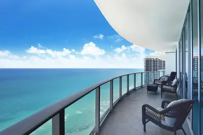 a balcony with chairs and a view of the ocean at Million Dollar Ocean Front Penthouse by Zen Vacation Rentals in Hollywood
