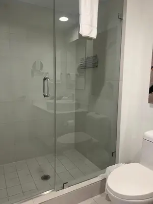 a shower stall in a bathroom with a toilet at BeachWalk Studio Steps from the Sand 2 Full Beds 805 B in Hallandale Beach