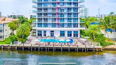 a resort with a dock with chairs and a pool at Designer Beachfront Apartment Views, Luxury & Full Kitchen 805 A in Hallandale Beach