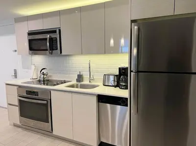 a kitchen with a stainless steel refrigerator and a sink at Luxury Stay in Miami Beach Stunning Views & Full Kitchen 20A in Hallandale Beach