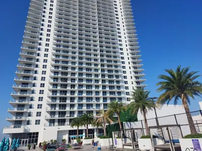 a large apartment building on the beach with palm trees at Modern Waterfront Retreat with Scenic Views in Hollywood
