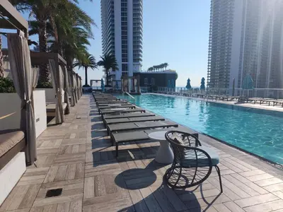a pool with a row of tables and chairs next to buildings at Modern Waterfront Retreat with Scenic Views in Hollywood