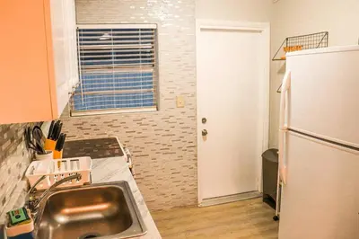 a kitchen with a sink and a refrigerator at Luxury House with Delightful Beach Style! in Dania Beach