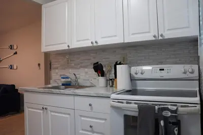 a kitchen with white cabinets and a stove at Luxury House with Delightful Beach Style! in Dania Beach