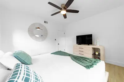 a bedroom with a bed and a ceiling fan at The Blue Parrot in Fort Lauderdale