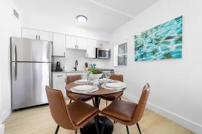a kitchen with a table with chairs and a refrigerator at The Blue Parrot in Fort Lauderdale