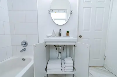 a white bathroom with a sink and a mirror at The Blue Parrot in Fort Lauderdale