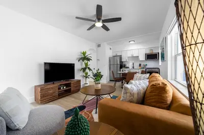 a living room with a couch and a tv at The Blue Parrot in Fort Lauderdale