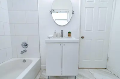 a bathroom with a sink and a tub and a mirror at The Blue Parrot in Fort Lauderdale