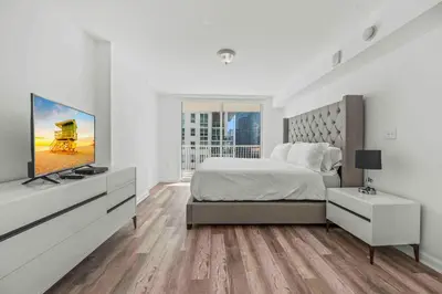 a white bedroom with a bed and a flat screen tv at Amazing 1 Bed 1 Bath • Brickell • City & Bay View in Miami