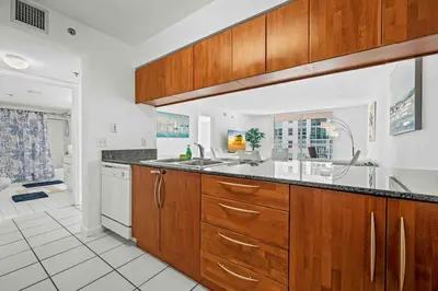 a kitchen with wooden cabinets and a sink at Amazing 1 Bed 1 Bath • Brickell • City & Bay View in Miami