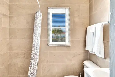 a bathroom with a shower with a toilet and a window at Charter House in Hollywood