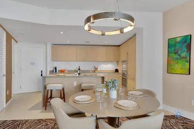 a kitchen with a table and chairs and a kitchen with a counter at Insane Ocean View Balcony - Beachfront Condo - Pool in Hollywood