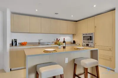 a kitchen with a counter with stools and a microwave at Insane Ocean View Balcony - Beachfront Condo - Pool in Hollywood