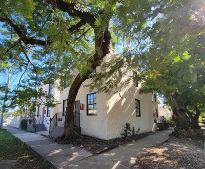 a white house with trees in front of it at Lovely Apartment Near Brickell 3 in Miami