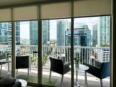 a room with a large window with tables and chairs at Top Stay Miami Green Brickell in Miami