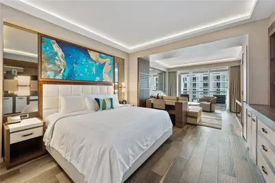 a bedroom with a large bed and a living room at Luxury Suite at Fort Lauderdale in Fort Lauderdale