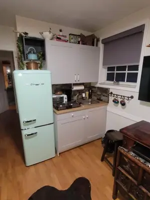 a kitchen with a white refrigerator and a table at The Cozy Villa-private parking in Miami