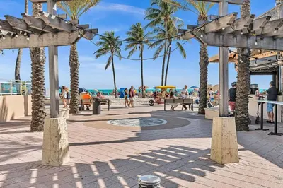 a beach with palm trees and people walking on the beach at Hollywood Vacation In Perfect Beach Location Ha01 in Hollywood