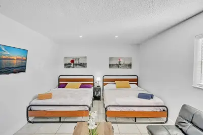 two beds in a room with a couch at Large 2 Bed Studio Close to Beach & Hard Rock HA03 in Hollywood