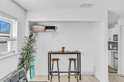 a small table in a living room with two stools at Large 2 Bed Studio Close to Beach & Hard Rock HA03 in Hollywood
