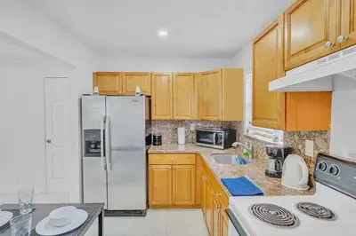 a kitchen with wooden cabinets and a stainless steel refrigerator at NEW 2 Bedroom Hollywood Beach and Hard Rock LB1 in Hollywood