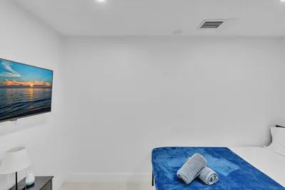 a bedroom with a bed and a tv on a wall at NEW 2 Bedroom Hollywood Beach and Hard Rock LB1 in Hollywood