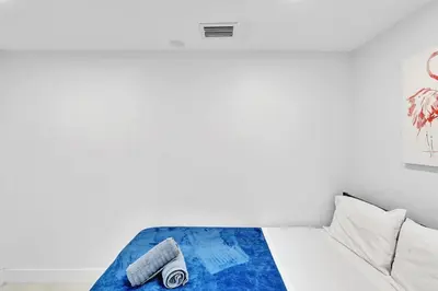 a white bedroom with a bed with two towels on it at NEW 2 Bedroom Hollywood Beach and Hard Rock LB1 in Hollywood