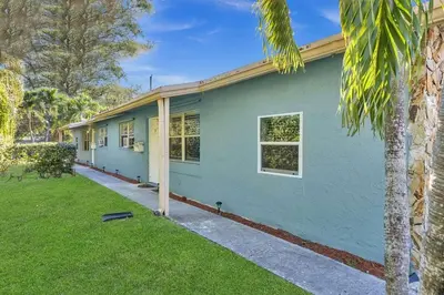 a green house with a palm tree in front of it at Hollywood 2 Bdrm New Furnished Beach Vacation LB2 in Hollywood