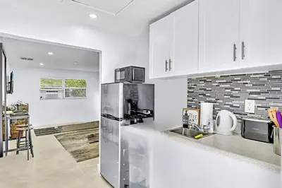 a kitchen with white cabinets and a stainless steel refrigerator at Hollywood Large Studio Close to Beach & Casino LB3 in Hollywood