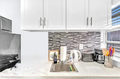 a kitchen with white cabinets and a sink at Hollywood Large Studio Close to Beach & Casino LB3 in Hollywood