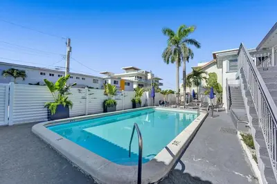 a swimming pool in front of a house at Waves On Desoto Rental Unit With Pool in Hollywood