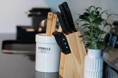 a white coffee cup next to a bunch of knives at Monte Carlo by Miami Vacations in Miami Beach