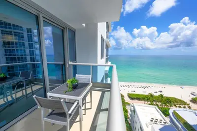 a balcony with a table and chairs and the ocean at Monte Carlo by Miami Vacations in Miami Beach