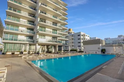 a swimming pool in front of a building at Monte Carlo by Miami Vacations in Miami Beach