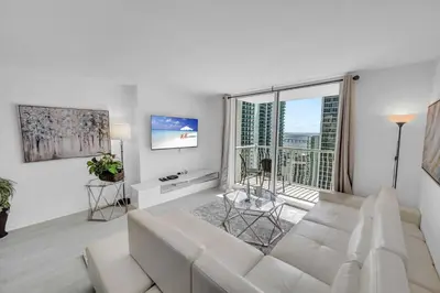 a living room with a white couch and a large window at Deluxe 1 Bedroom Apartment • Brickell • Ocean View in Miami